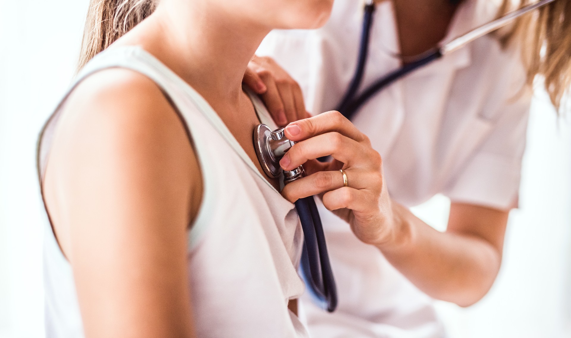 Joven doctora examinando a una pequeña muchacha en su oficina.